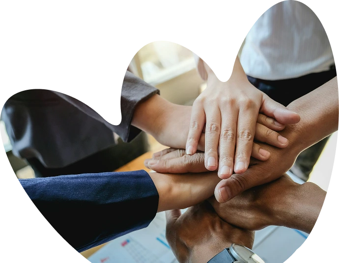 Several people stack their hands together in a show of unity and teamwork, framed by a heart-shaped border—a touching symbol of support at Sunflower Children’s Hospice.