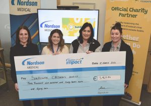 Four women smile while holding a large cheque for €3,947.80 made out to Sunflower Children’s Hospice from Nordson Medical, celebrating their partnership. Banners for Nordson Medical and Sunflower Foundation are visible in the background.
